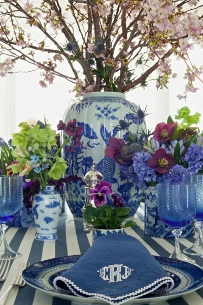 A table setting in blue and white china beneath branches of blossom