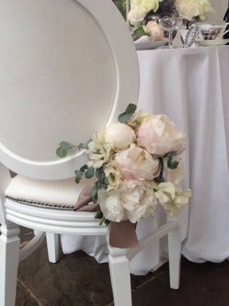 Peonies tied to the back of a white chair