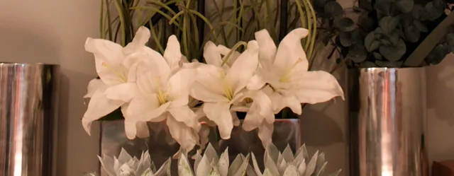 White lilies between mirrored vases