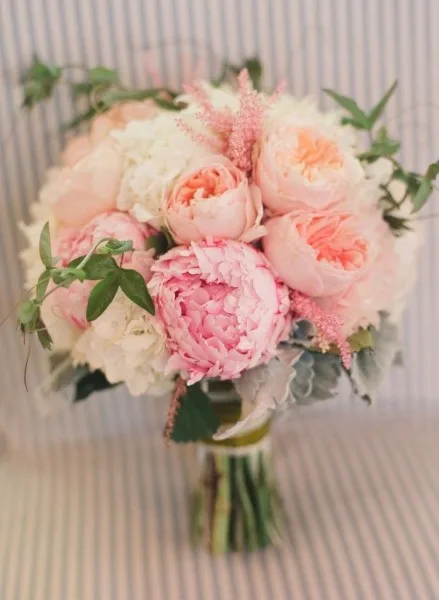 A bridal bouquet of blush and coral peonies