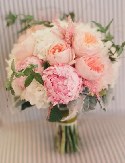 A bridal bouquet of blush and coral peonies