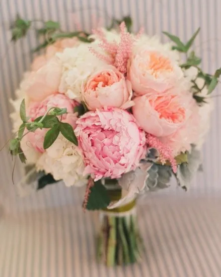 A bridal bouquet of blush and coral peonies