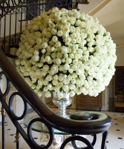 A large dome of white roses at the foot of a staircase