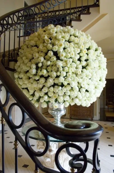 A large dome of white roses at the foot of a staircase